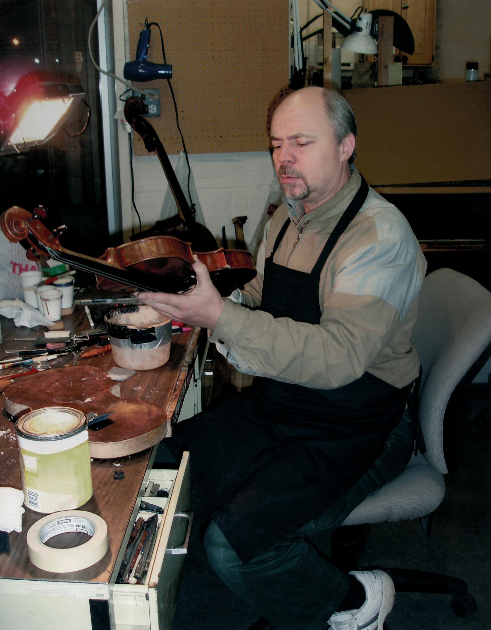 Slava Miniaev inspecting a violin for repair